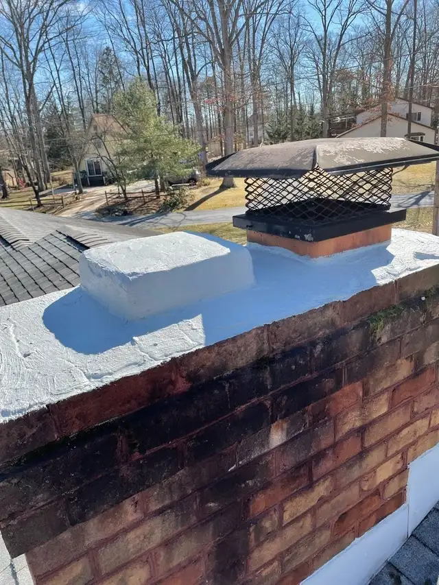 After: the same chimney with a rebuilt crown sealed in a white waterproof coat